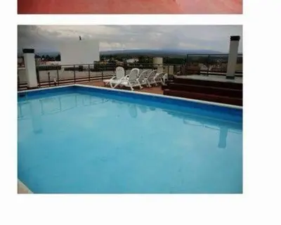 a large blue swimming pool on top of a building at Dulces Sueños in Villa Carlos Paz