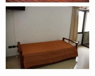 a wooden bed in a room with a window at Dulces Sueños in Villa Carlos Paz