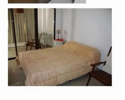 a bedroom with a bed and a chair in a room at Dulces Sueños in Villa Carlos Paz