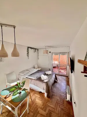 a bedroom with a bed and a table in it at Refugio urbano frente a Sanatorio Allende in Cordoba