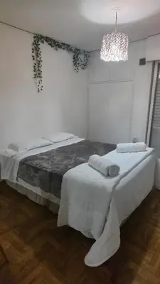 a bedroom with two beds and a chandelier at Refugio urbano frente a Sanatorio Allende in Cordoba