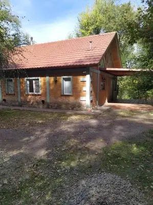 a small brick house with a red roof at Chalet del arroyo in La Porteña