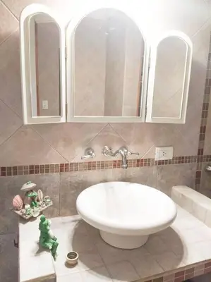 a bathroom with a tub and a sink and a mirror at Chalet del arroyo in La Porteña
