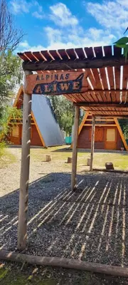 a wooden structure with a sign in front of a building at Alpinas Aliwé in San Ignacio