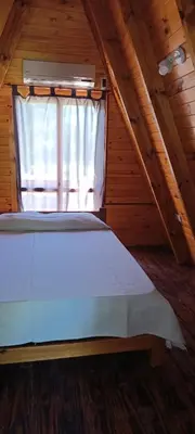 a large bed in a attic with a window at Alpinas Aliwé in San Ignacio