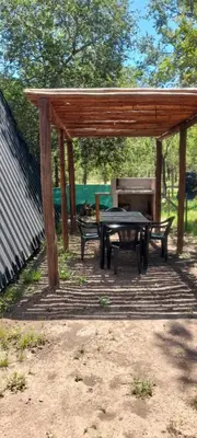 a wooden pavilion with a picnic table and a grill at Alpinas Aliwé in San Ignacio