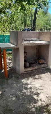 a concrete bench sitting in a park next to a tree at Alpinas Aliwé in San Ignacio