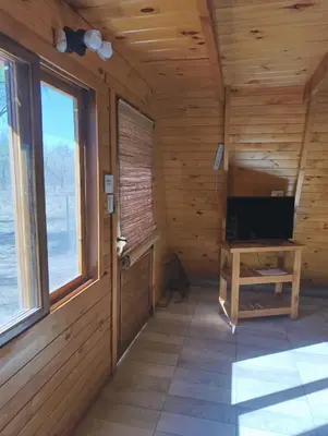 a room with wooden walls and windows and a desk at Alpinas Aliwé in San Ignacio