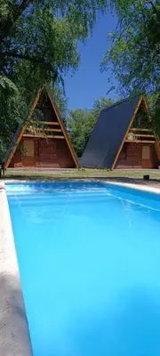 a house with a roof with a swimming pool at Alpinas Aliwé in San Ignacio
