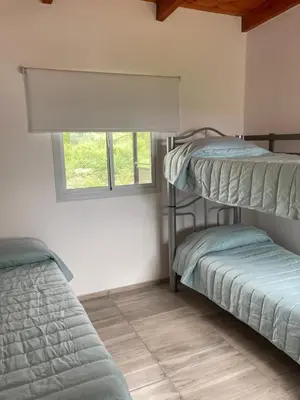 two bunk beds in a room with a window at Departamento ideal Pileta, Parrilla y Pet friendly in Cavalango