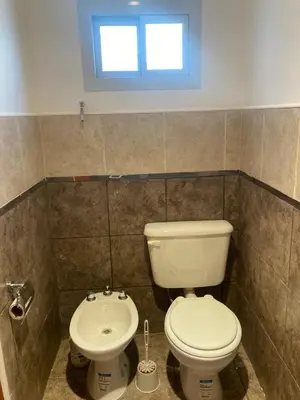 a bathroom with a toilet and a sink at Departamento ideal Pileta, Parrilla y Pet friendly in Cavalango