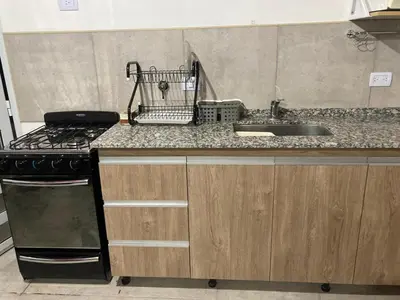 a kitchen with a sink and a stove top oven at Departamento ideal Pileta, Parrilla y Pet friendly in Cavalango