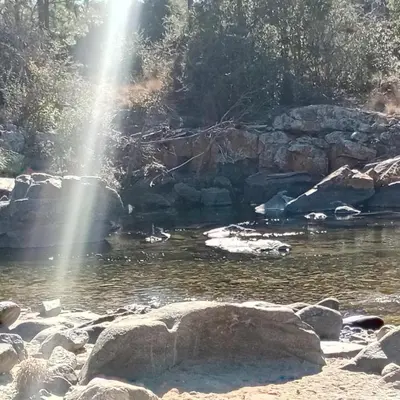 a pool of water with a waterfall and rocks at Cabañas Mate de Luna in Santa Rosa de Calamuchita