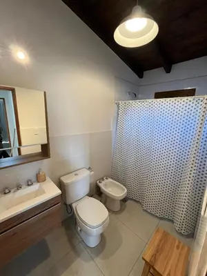 a bathroom with a toilet and a sink and a shower at Las Champas in Villa Yacanto