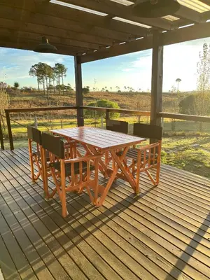 a wooden table and chairs on a wooden deck at Las Champas in Villa Yacanto