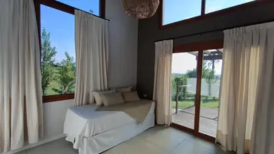 a bedroom with a bed and a large window at Las Champas in Villa Yacanto