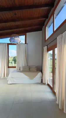 a bedroom with a bed and large windows at Las Champas in Villa Yacanto