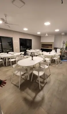 a room with white tables and white chairs at Girolami Temporarios Villa Carlos Paz in Villa Carlos Paz