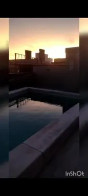 a swimming pool with the sunset in the background at Girolami Temporarios Villa Carlos Paz in Villa Carlos Paz