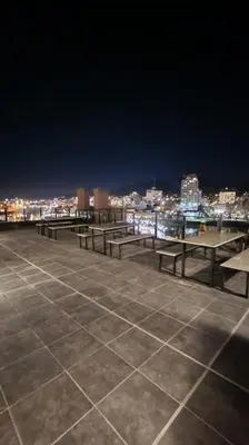 a group of picnic tables on a rooftop at night at Girolami Temporarios Villa Carlos Paz in Villa Carlos Paz