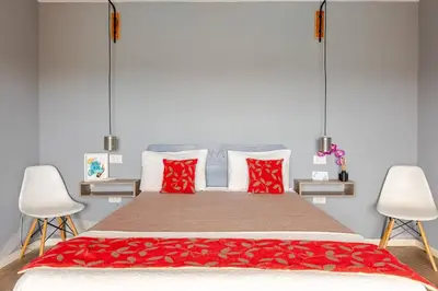 a bedroom with a large bed with red pillows at Casa Dos Lunas in Bialet Massé