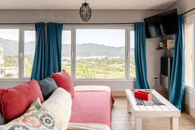 a living room with a couch and a large window at Casa Dos Lunas in Bialet Massé