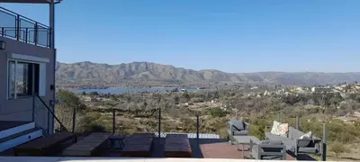 a balcony of a house with chairs and a view at Casa Dos Lunas in Bialet Massé