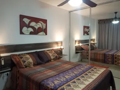 a bedroom with two beds and a mirror at NGdeptosVCP in Villa Carlos Paz
