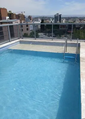 a large blue swimming pool on top of a building at NGdeptosVCP in Villa Carlos Paz