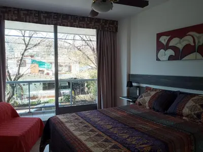 a bedroom with a bed and a large window at NGdeptosVCP in Villa Carlos Paz
