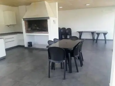 a room with a table and chairs and a fireplace at NGdeptosVCP in Villa Carlos Paz