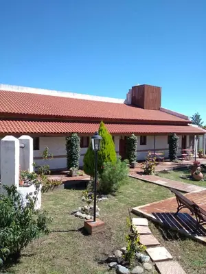 a building with a bench and a street light in a yard at Hosteria Manantial de Carpintería in Carpintería