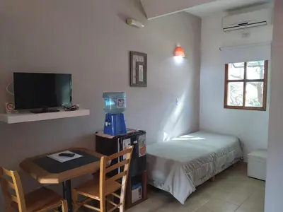 a small room with a small table and a bed at Hosteria Manantial de Carpintería in Carpintería