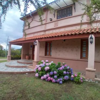 a house with flowers in front of it at Hosteria Manantial de Carpintería in Carpintería