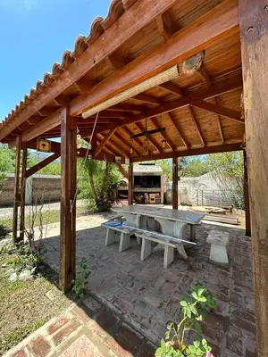 a wooden pavilion with a picnic table under it at Hosteria Manantial de Carpintería in Carpintería