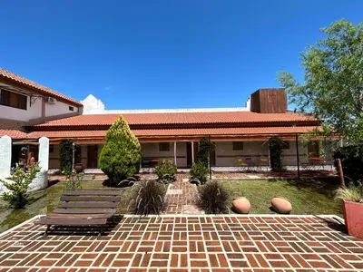 a house with two benches and a brick patio at Hosteria Manantial de Carpintería in Carpintería