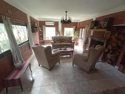 a living room with a couch and chairs and a fireplace at Casa familiar de Campo Arev in Las Rabonas