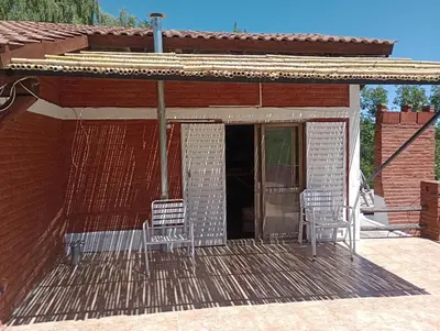 two chairs sitting on a porch of a house at Casa familiar de Campo Arev in Las Rabonas