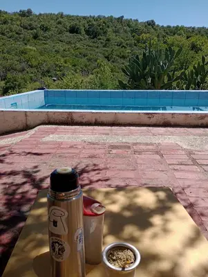 a table with a thermos and a bowl of food at Casa familiar de Campo Arev in Las Rabonas