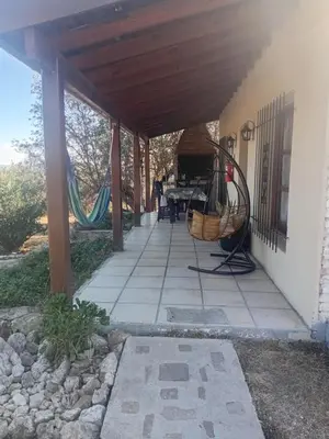 a porch of a house with awning and a swing at Casitas de Campo in Mina Clavero