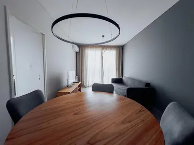 a dining room with a wooden table and a couch at MR HOST 20 | Departamento de Diseño en Torre Neos Park in Río Cuarto