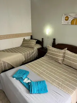 two beds in a room with blue towels on them at Nuevo Hotel Córdoba in Villa Carlos Paz
