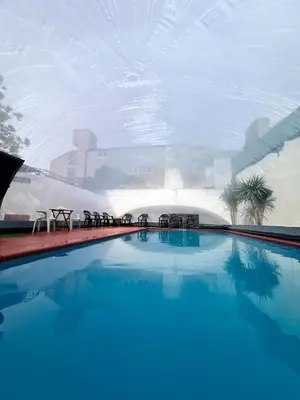 a large swimming pool with a city in the background at Nuevo Hotel Córdoba in Villa Carlos Paz