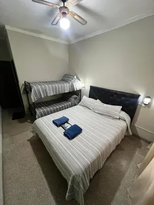 a bedroom with a bed with two blue towels on it at Nuevo Hotel Córdoba in Villa Carlos Paz