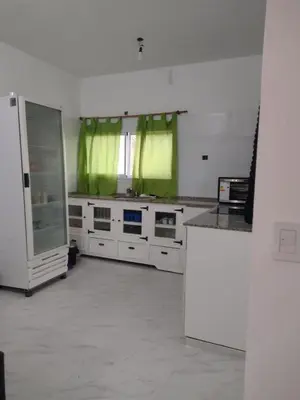 a kitchen with white cabinets and green curtains at Mi lugar en el mundo in Cortaderas