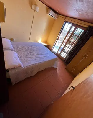 a small bedroom with a bed and a window at Cabaña Villa Carlos Paz in Villa Carlos Paz