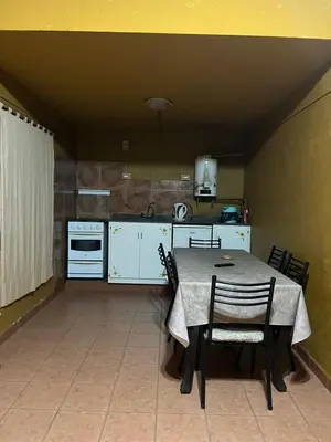 a kitchen with a table and chairs in a room at Cabaña Villa Carlos Paz in Villa Carlos Paz