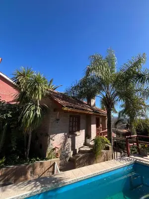 a house with a swimming pool in front of a house at Cabaña Villa Carlos Paz in Villa Carlos Paz