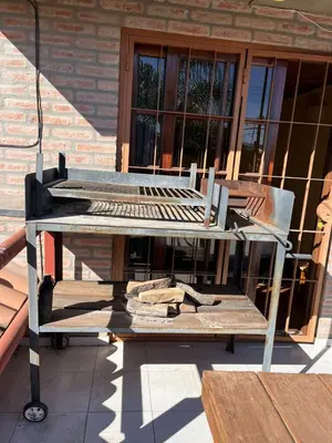a picnic table sitting on a porch next to a building at Cabaña Villa Carlos Paz in Villa Carlos Paz