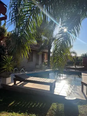 a wooden bench sitting next to a swimming pool at Cabaña Villa Carlos Paz in Villa Carlos Paz